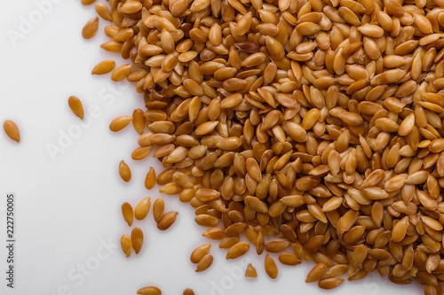 Seeds of golden flax on a white background