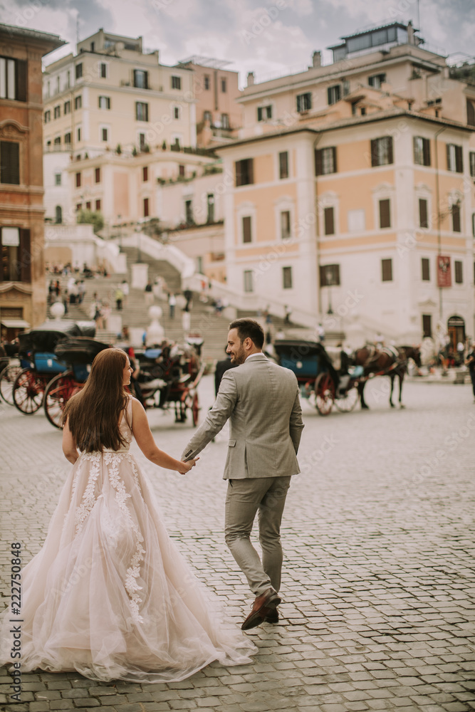 Young wedding couple near Spanish steps (Scalinata di Trinità dei Monti) in Rome, Italy