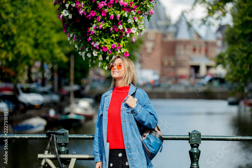 Photography Young girl in red sweater and orange sunglasses with backpack at bridge in Amsterdam street