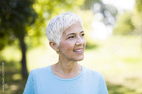 Portrait of a smiling sporty senior woman in a park