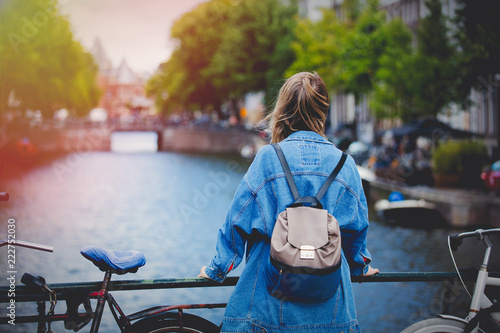 Photography Young girl in jeans jacket and backpack at bridge in Amsterdam street