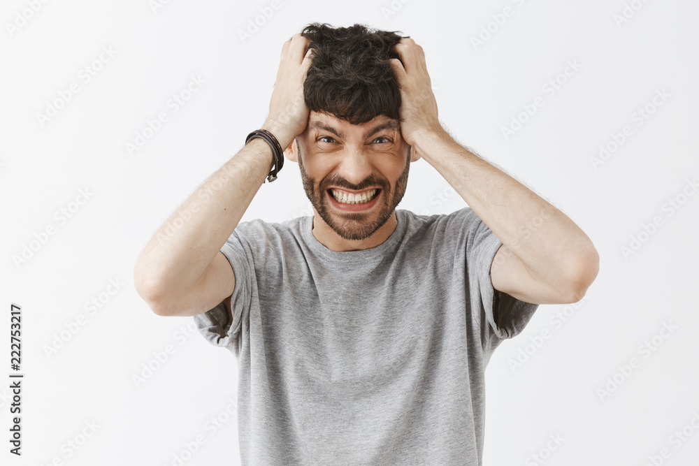 Pissed and distressed angry european man with beard pulling hair out of head  clenching teeth and frowning from dislike and fury, feeling outraged over  gray background, being over-emotional Stock Photo | Adobe