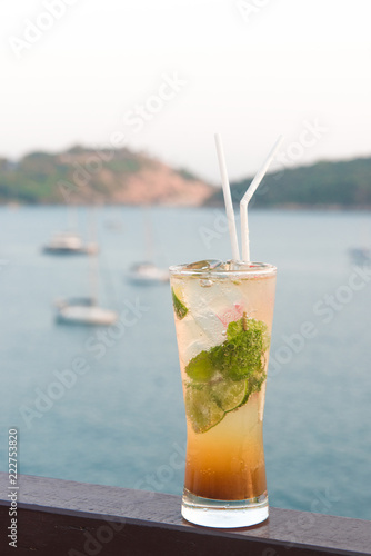 Mojito cocktail drink with evening sunset on beach background