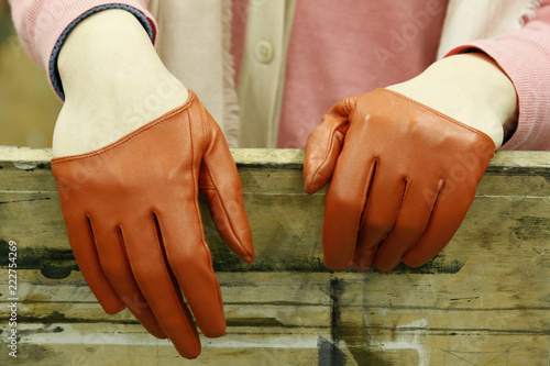 Vintage leather gloves. Woman's hands wearing brown reddish vintage gloves.Elegance and fancy look. Beauty and fashion.