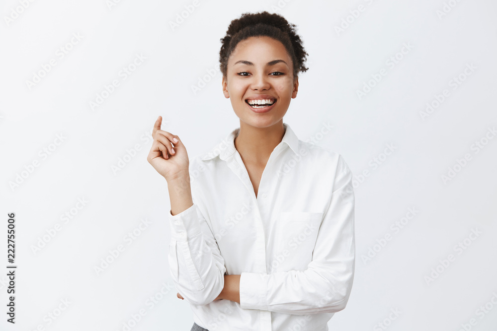 Successful attractive african-american businesswoman gazing with confidence and daring look at company who lost in competition, laughing out loud from joy, triumphing with coworkers