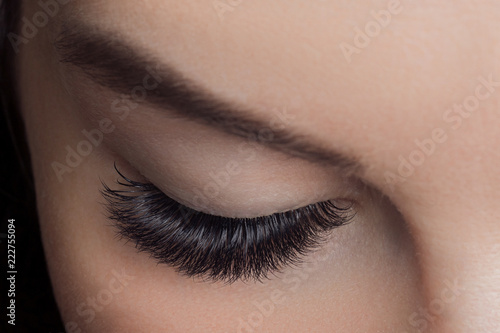 Woman with long lashes in beauty salon. Concept eyelash extension procedure.
