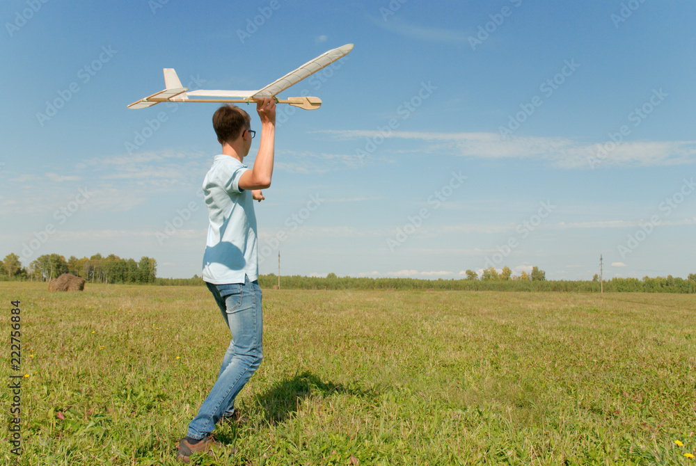 Teenager  throwing DIY glider in the grass. Dream conception photo.