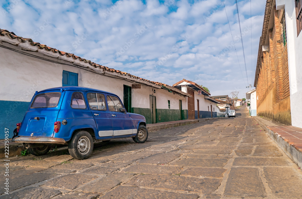 Barichara, Colombia, Santander, colonial street with white historic buildings with old car