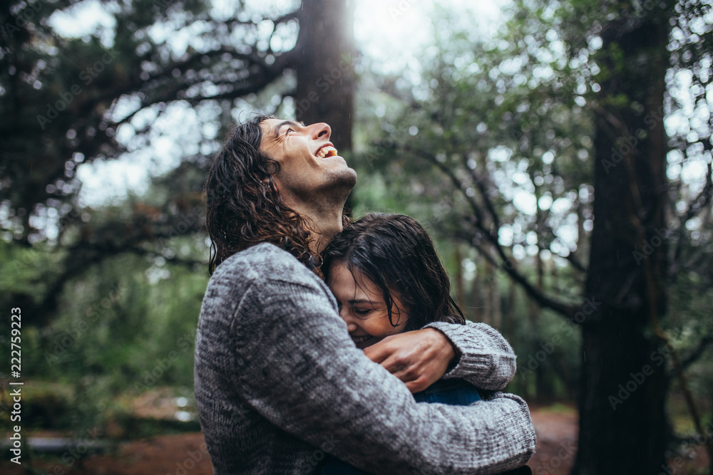 Obraz premium Couple in love embracing in the park under rain