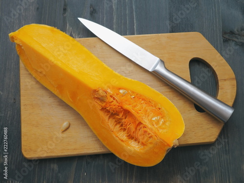 Top view of quarter of ripe pumpkin arranged upon cutting board. Cooking with butternut squash. Selective focus.