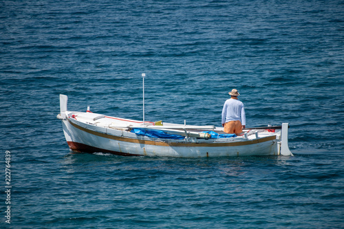 Fisherman in traditional wooden boat at sea