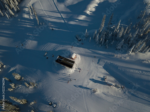 Aerial photo of skiing trails and runs go through the beautiful forest covered mountains photo