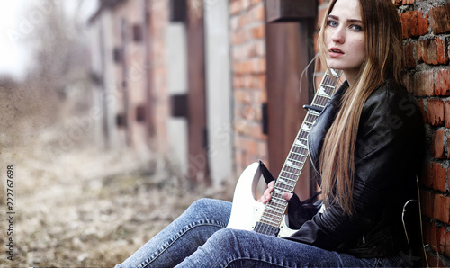 Beautiful young girl rocker with electric guitar. A rock musicia photo