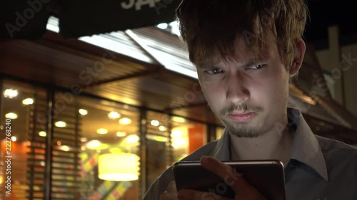 young handsome teenager using smartphone in the night city