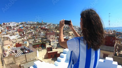 Woman taking pictures of the famous tanger medina from a wonderful terrace