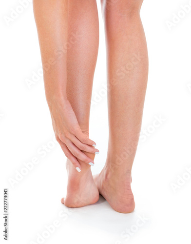 pain in the foot, female legs, shot in studio white background © sasapanchenko
