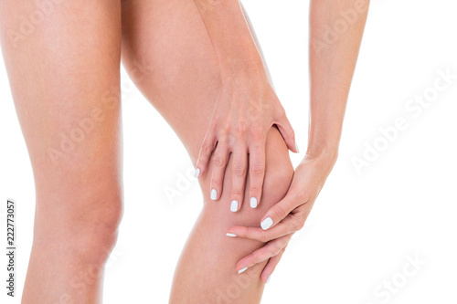 knee pain, female legs, shot in studio white background © sasapanchenko