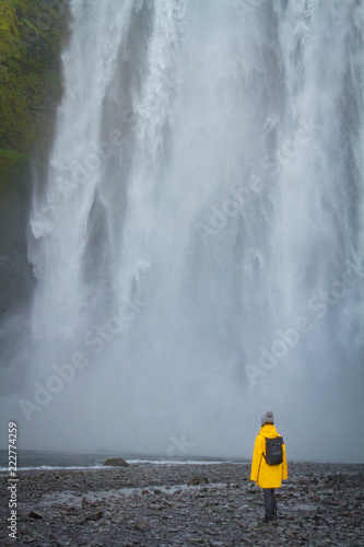 Woman stay on waterfall in Iceland, hide waterfall in Iceland, amazing sights and places to explore
