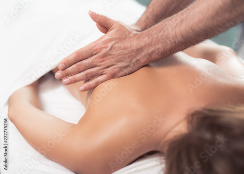 Relax and health care. Close up portrait therapist hands treating lady with spa procedure. Woman lying on massage table under white blanket