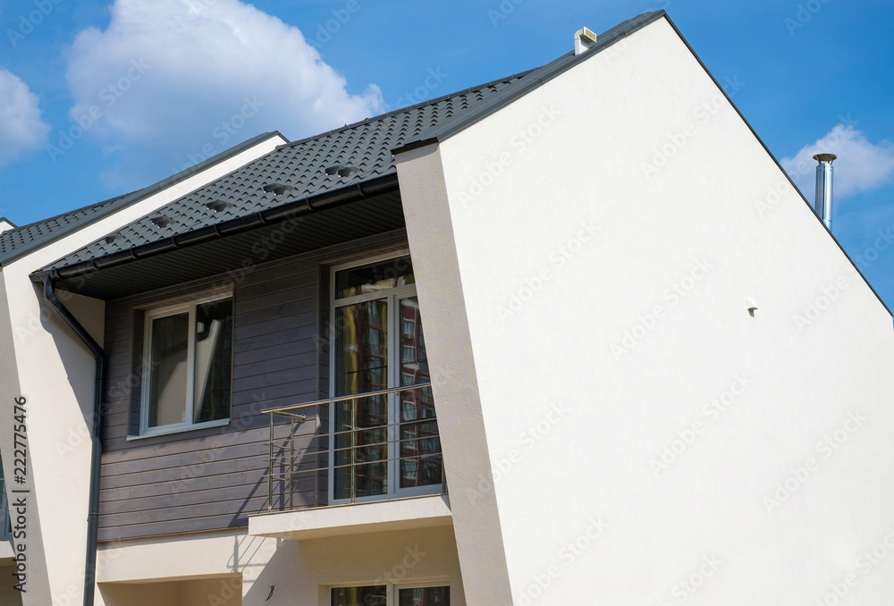 New modern house with plastic windows, metal roof, ventilation, chimney and rain gutter. New modern house with plastic windows, metal roof, ventilation, chimney and rain gutter.