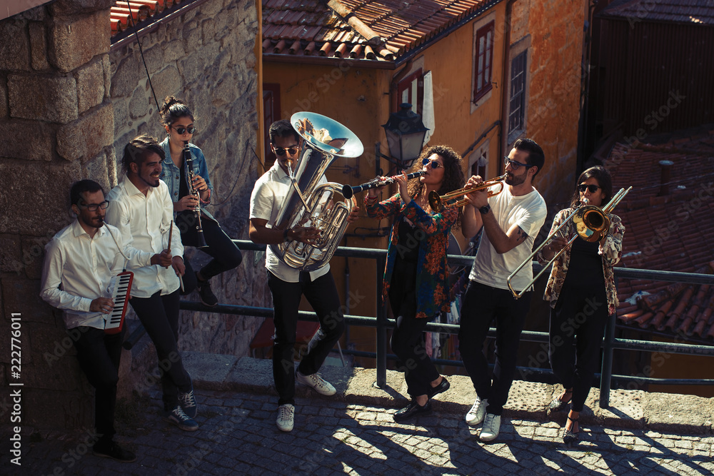 Naklejka premium Jazz band a group of musicians with wind instruments playing on the street of the city.