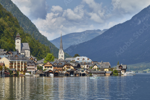 Hallstatt village landscape with old buildings reflected in blue lake. photo