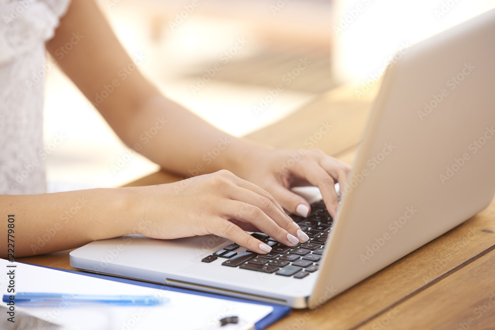 Fototapeta premium Close-up of woman typing on laptop