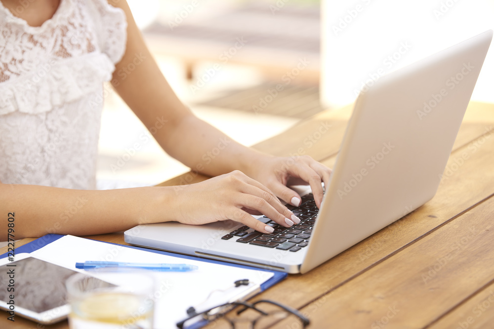 Close-up of woman typing on laptop Close-up of woman typing on laptop