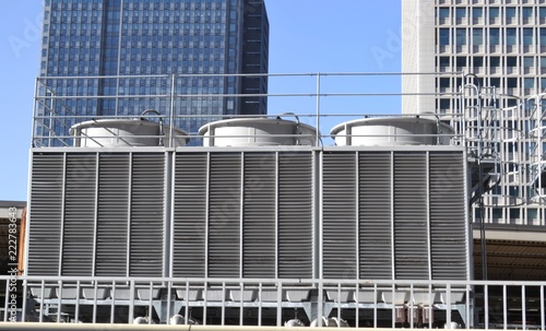 HVAC cooling tower heat exchanger on top of a building in front of commercial building stocks photo