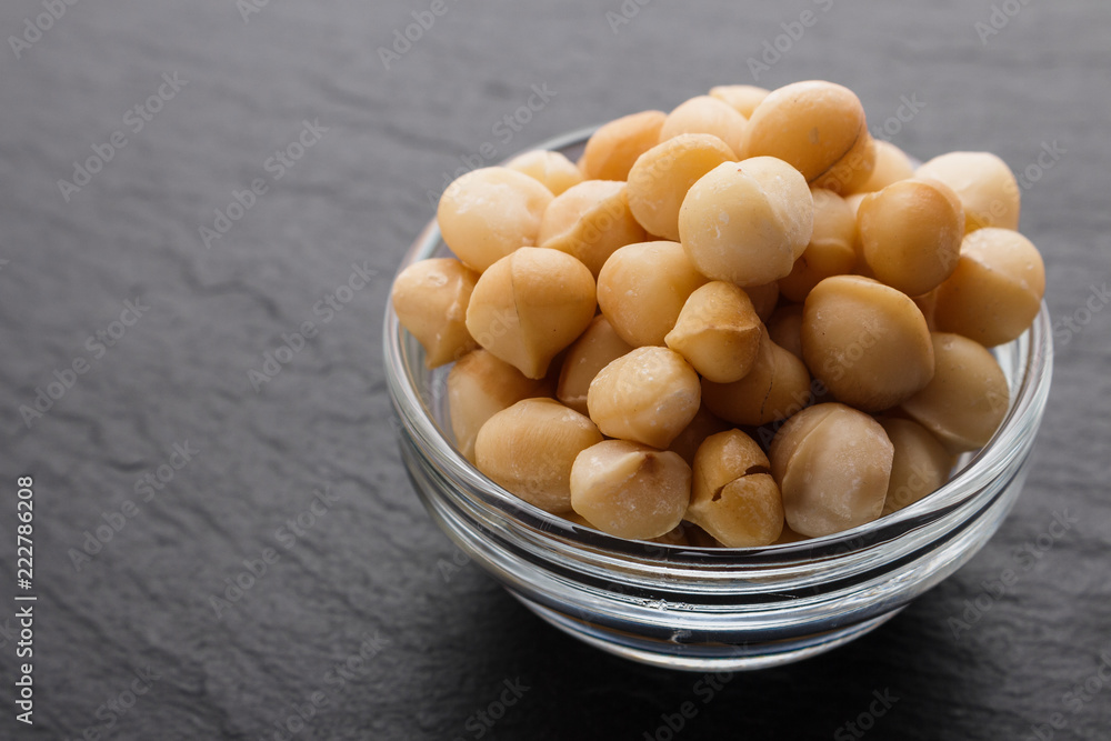 delicious macadamia nuts on a dark stone background delicious macadamia nuts on a dark stone background