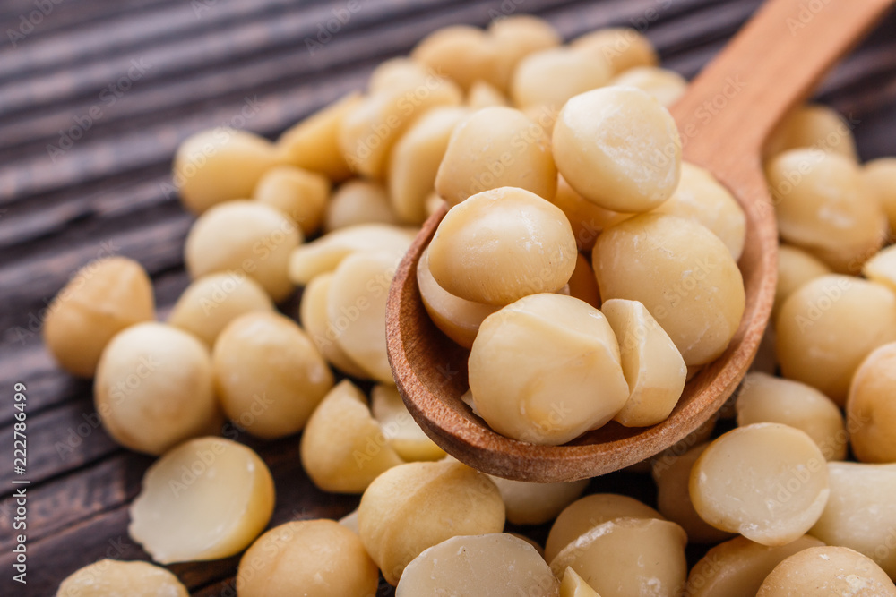 delicious macadamia nuts on a wooden rustic background delicious macadamia nuts on a wooden rustic background