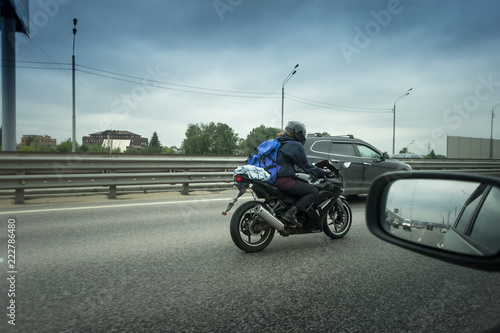 young man riding sport motorcycle on the highway with metal safety barrier or rail photo