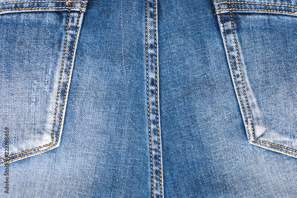 Back of the jeans, with pockets. Close up of details of jeans trousers with orange stitches. orange seam on jeans. Back of the jeans, with pockets. Close up of details of jeans trousers with orange stitches. orange seam on jeans.