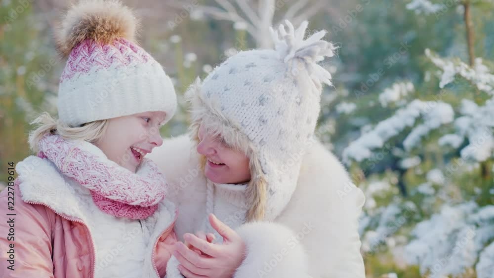 Portrait of a mother with her daughter on a background of snow-covered trees Portrait of a mother with her daughter on a background of snow-covered trees
