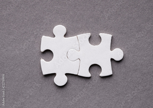Two interlocked puzzle pieces, teamwork concept