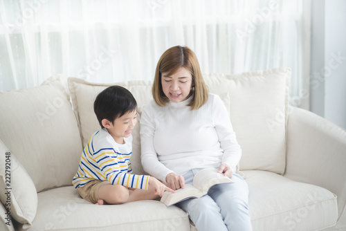 Asian mother Sitting With Son Reading Story together