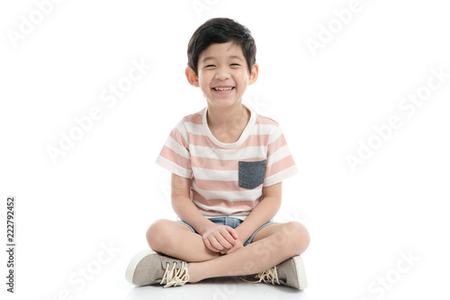 Cute Asian child sitting on white background isolated