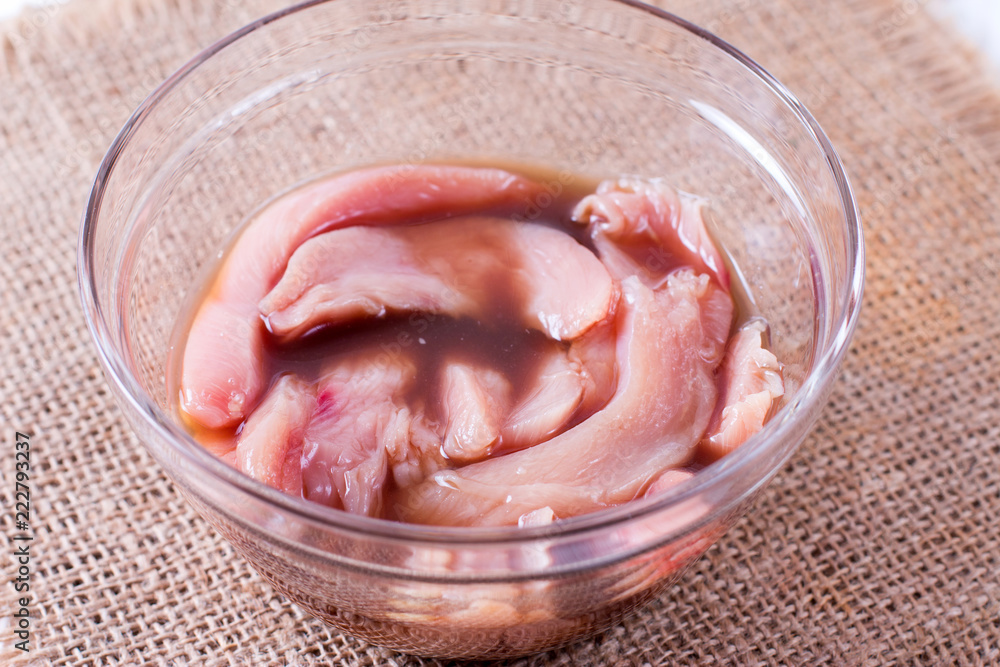 Raw Chicken Breast with Soy Sauce in White Bowl Raw Chicken Breast with Soy Sauce in White Bowl