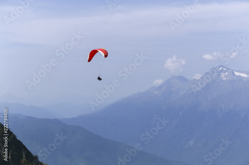 Paraplane on the blue sky background and mountains, leisure activity.