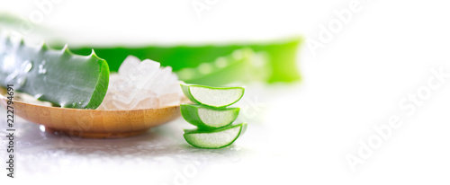 Aloe Vera gel closeup on white wooden background. Organic sliced aloevera leaf and gel, natural organic cosmetic ingredients for sensitive skin, alternative medicine. Skincare concept
