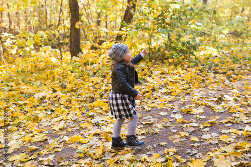 Fall  childhood  people concept - little happy girl walking in autumn park