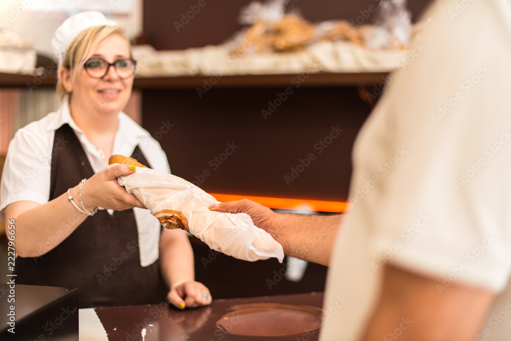 Obraz premium Man buying a loaf of bread in a bakery