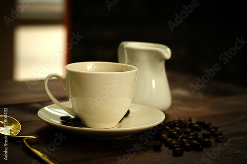 Coffee beans, glass and equipment for drinking coffee with warm light