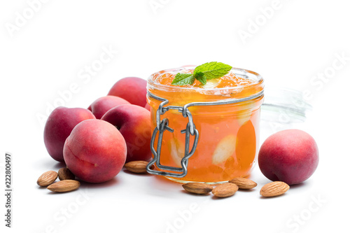 Red apricot  jam with almonds in a clear glass jar isolated on white
