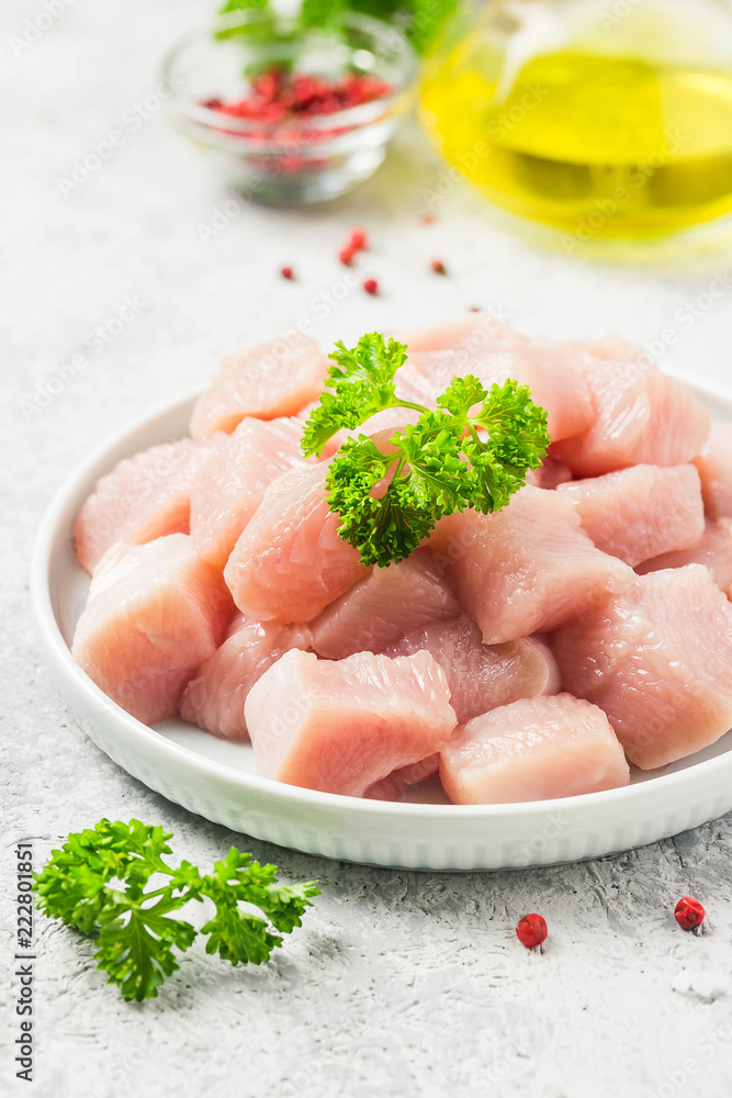 Raw meat cubes in a bowl with parsley, seasonings and olive oil. Selective focus, space for text. Raw meat cubes in a bowl with parsley, seasonings and olive oil. Selective focus, space for text.