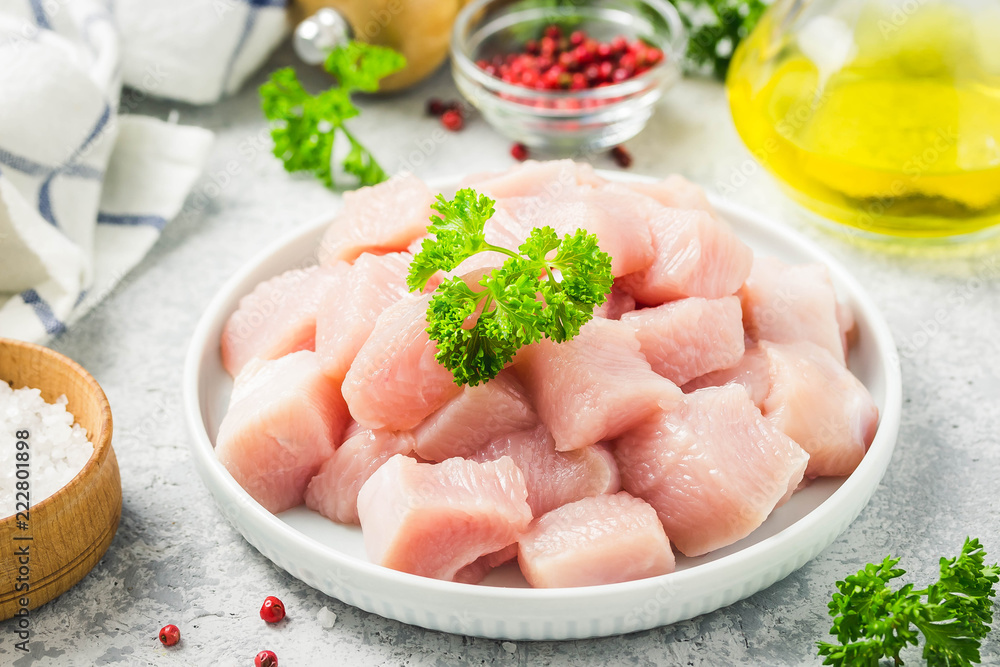 Raw meat cubes in a bowl with parsley, seasonings and olive oil. Selective focus, space for text. Raw meat cubes in a bowl with parsley, seasonings and olive oil. Selective focus, space for text.