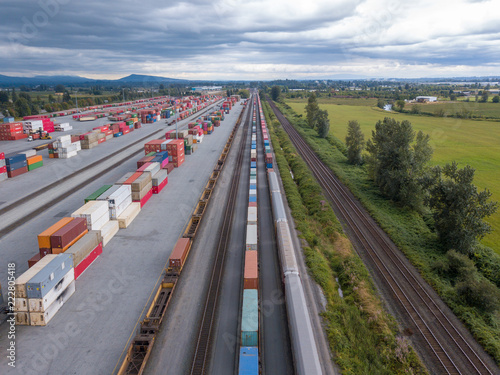 Industrial site and transportation platform with train convoy aerial view opposite to canada countryside
