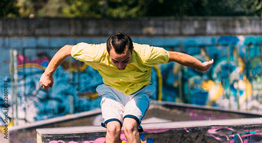 Obraz premium Sportive man running through obstacles in skatepark