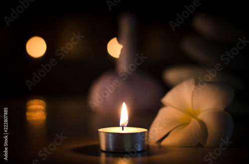 Spa concept: candle, Plumeria, stone with warm light in the dark