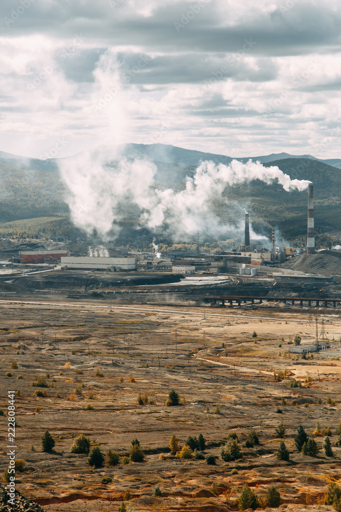 Fototapeta premium The dirtiest city, the factory in nature and the mountains of garbage. Smokestacks of the enterprise, violation of ecology. Coal processing